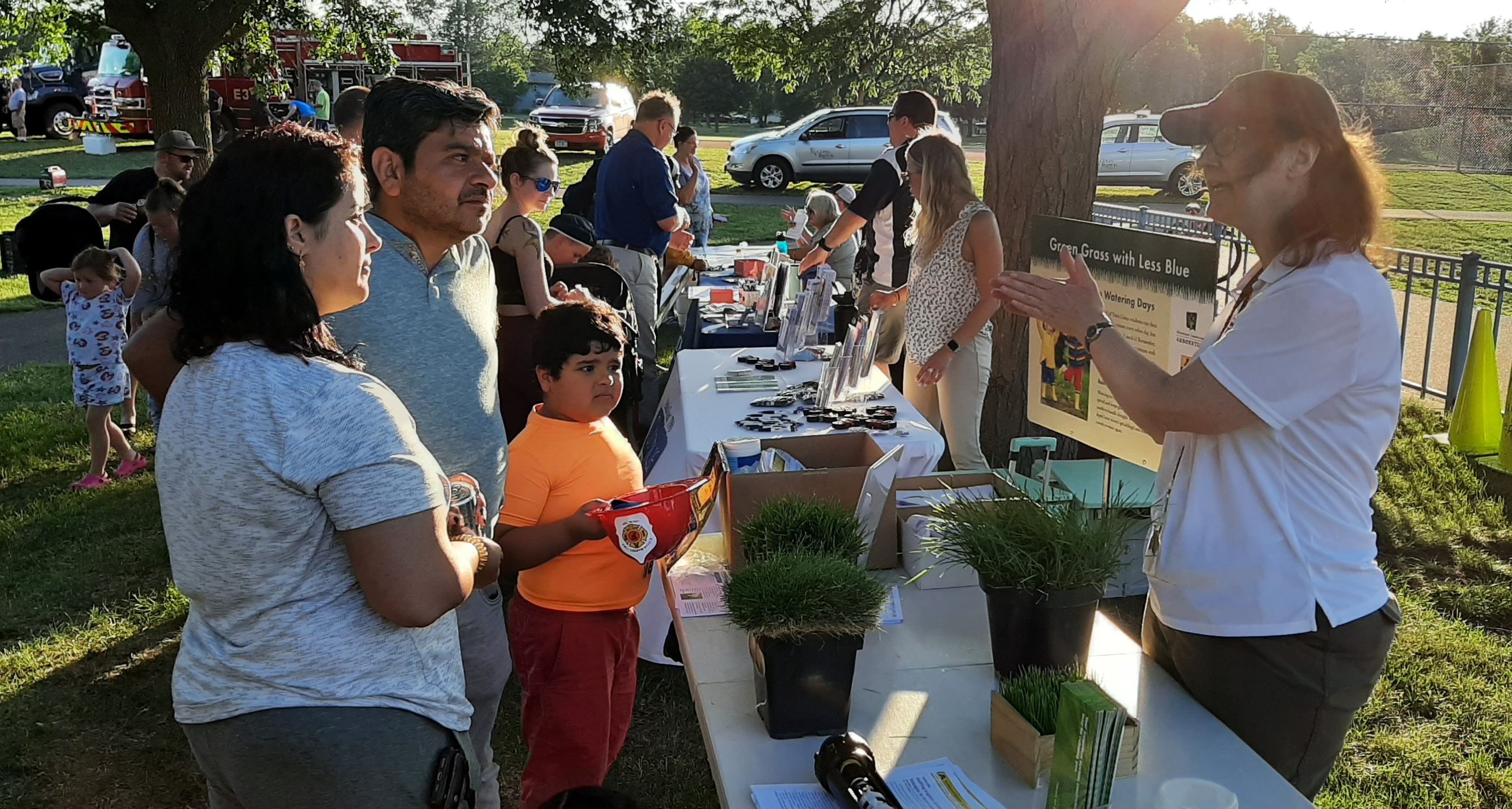 a person discussing lawn care with a family at an outdoor event