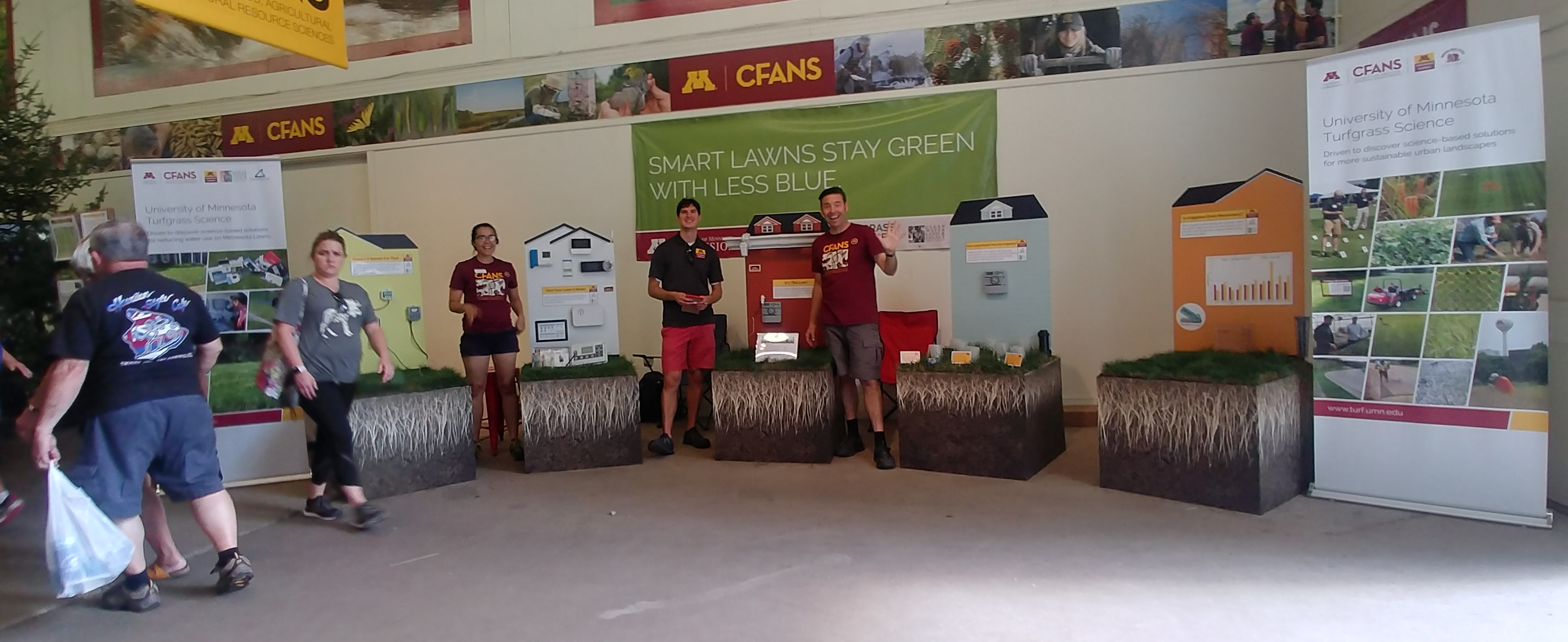 UMN turfgrass team at the state fair standing near a display