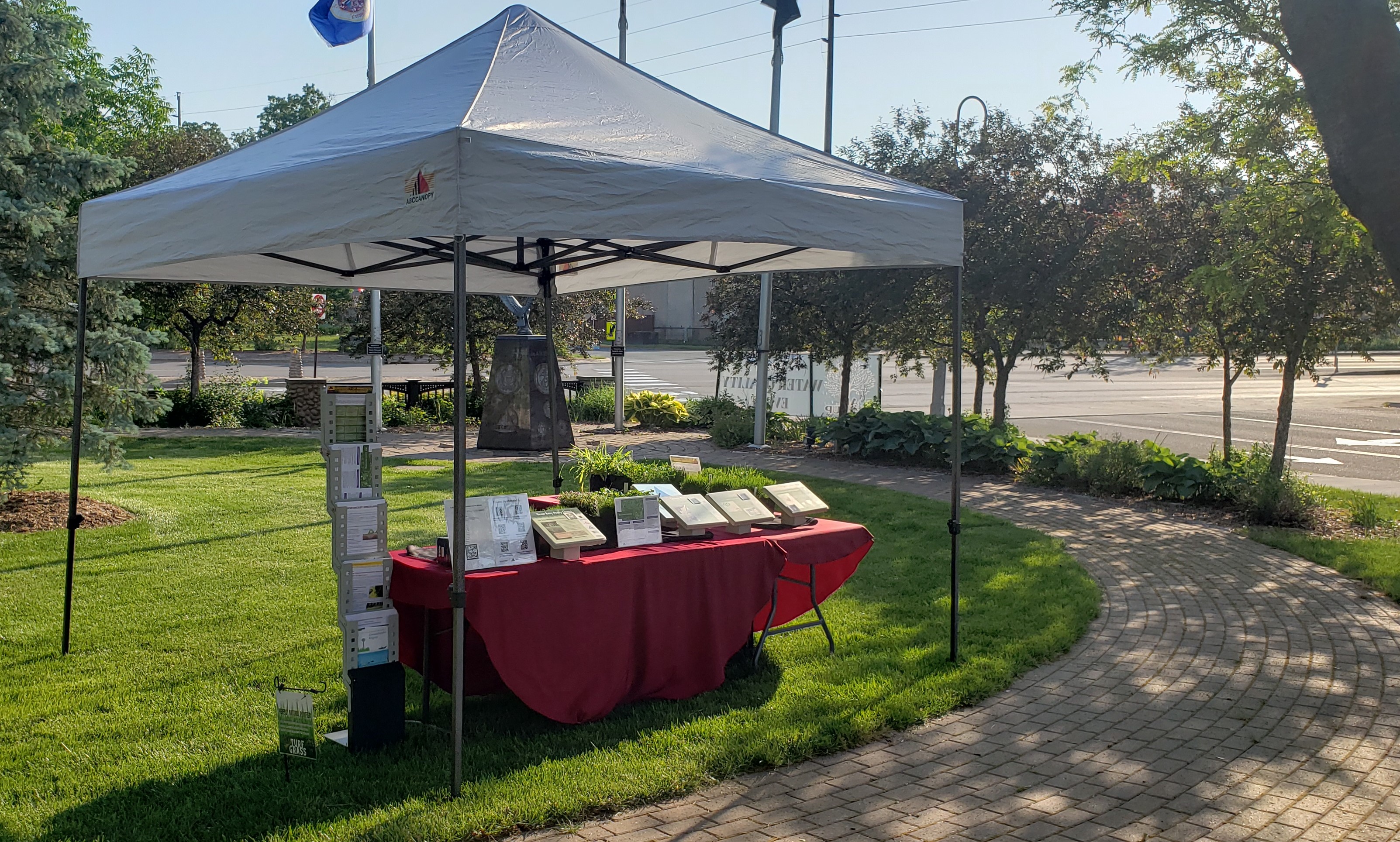a canopy with a lawn care educational display at an outside event