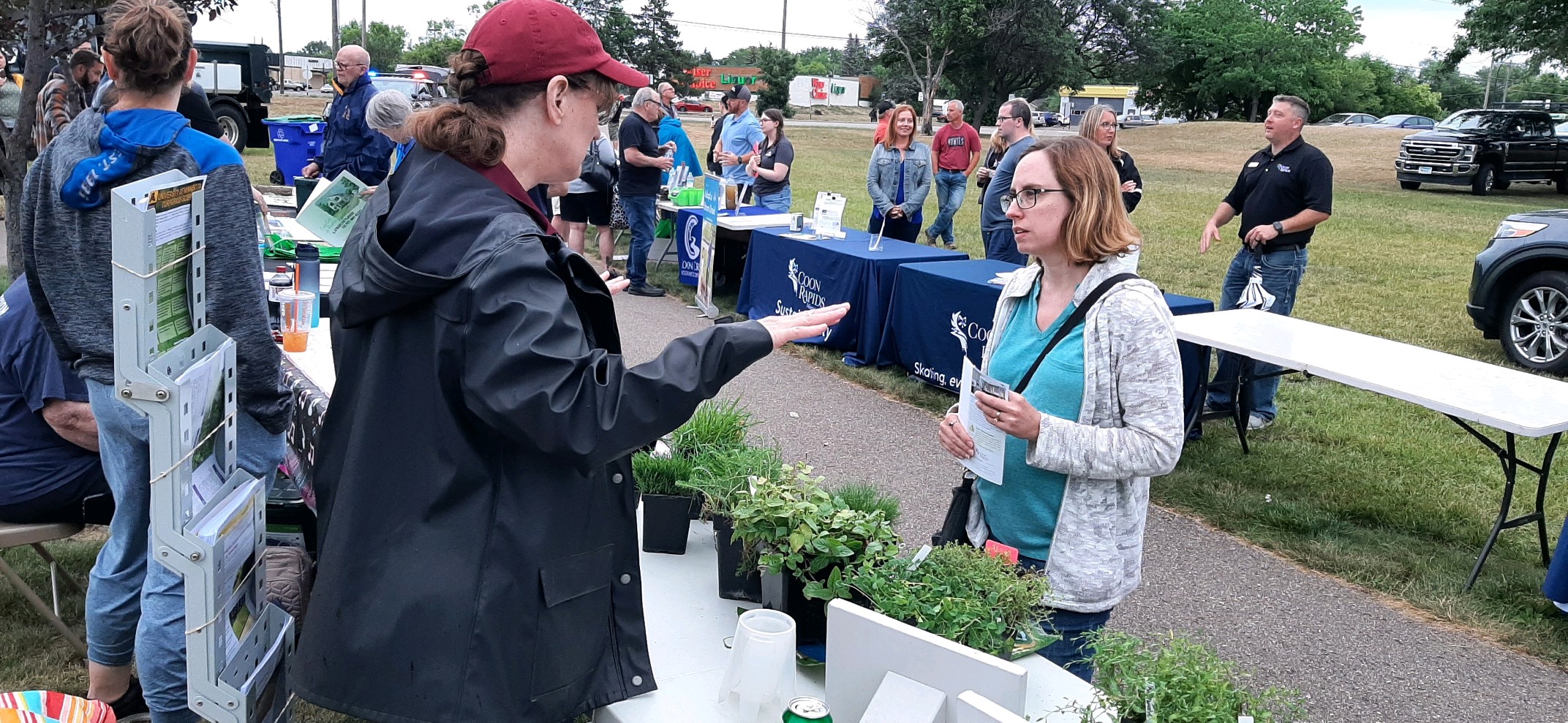 a woman at a turfgrass educational display talking to an event participant