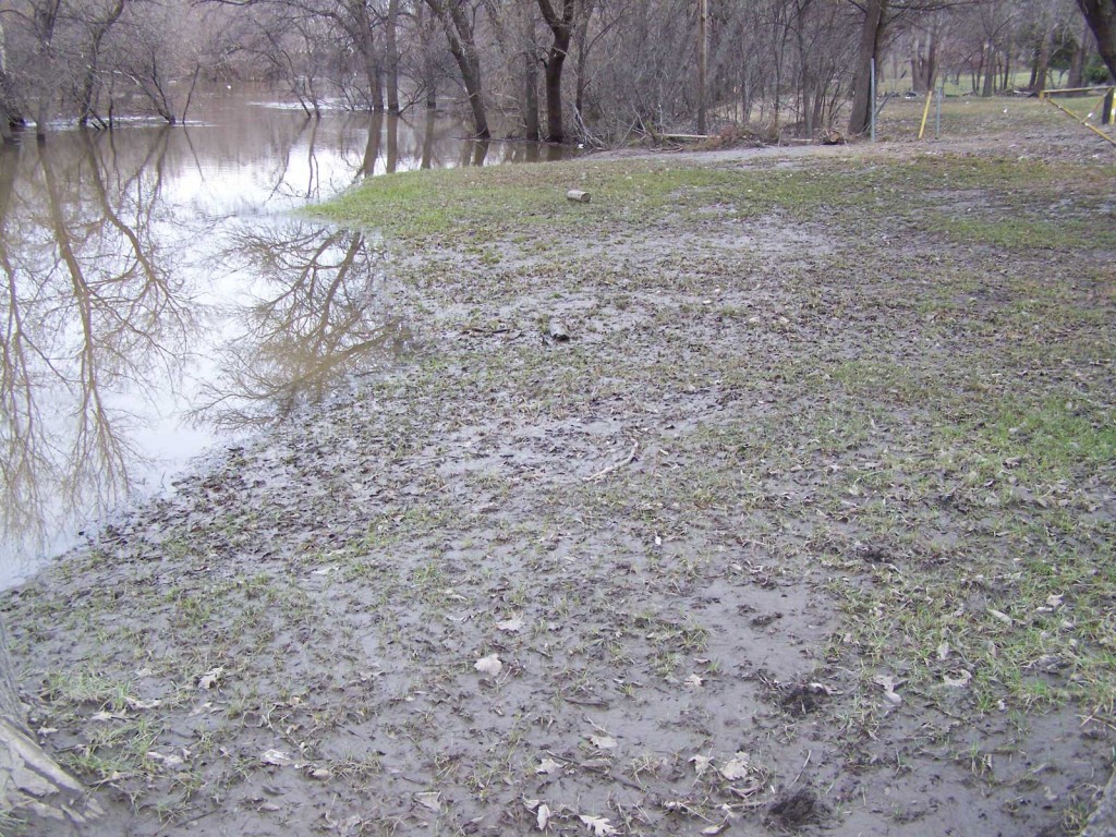 A spring flooded lawn covered in silt and debris.