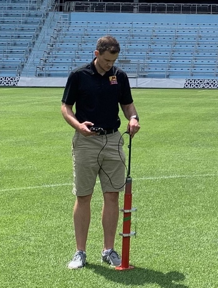 Chase Straw taking measurements in a soccer stadium